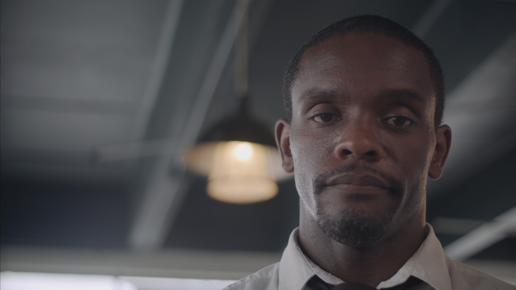 Close up of the face of a black man looking at the camera